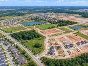 Aerial surveying view of a master-planned community with completed neighborhoods, roads, ponds, green spaces, and active construction areas.