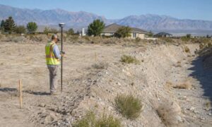 Surveyor conducting a flood elevation survey near a dry wash in Pahrump, Nevada